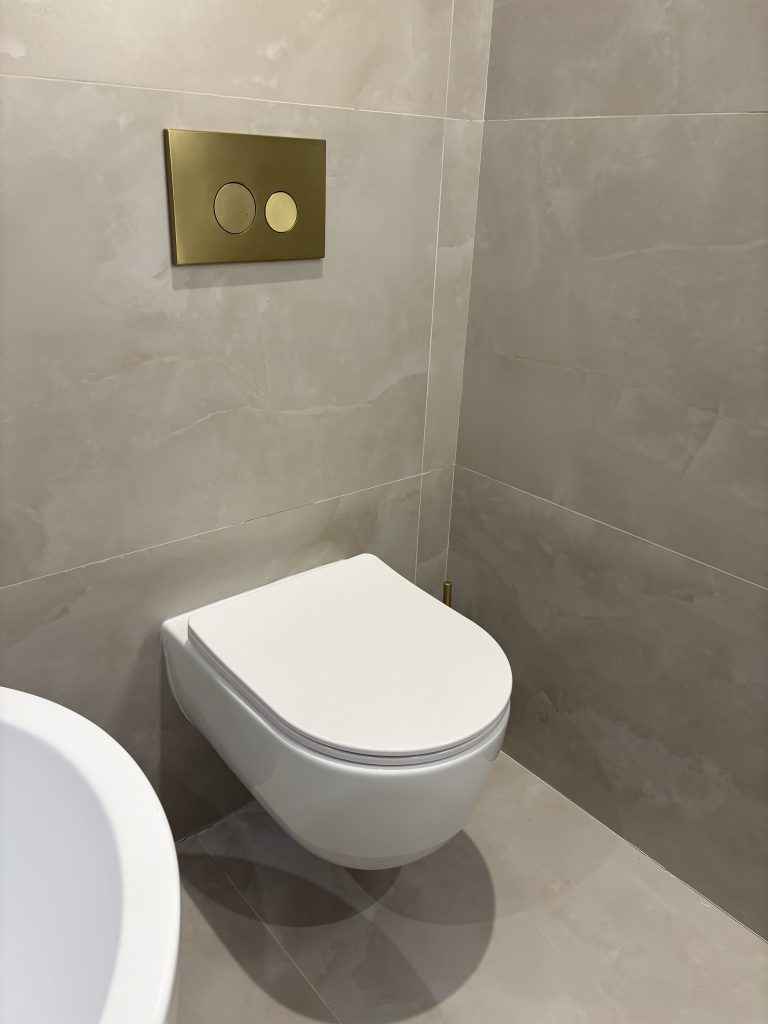 Beige marble cloakroom with gold flush plate, fitted by Premier Gas Burnley