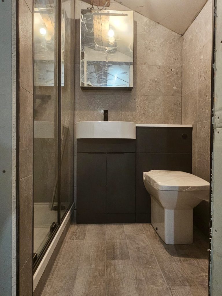 Dark wood vanity unit and quadrant shower enclosure in a bathroom fitted by Premier Gas Burnley