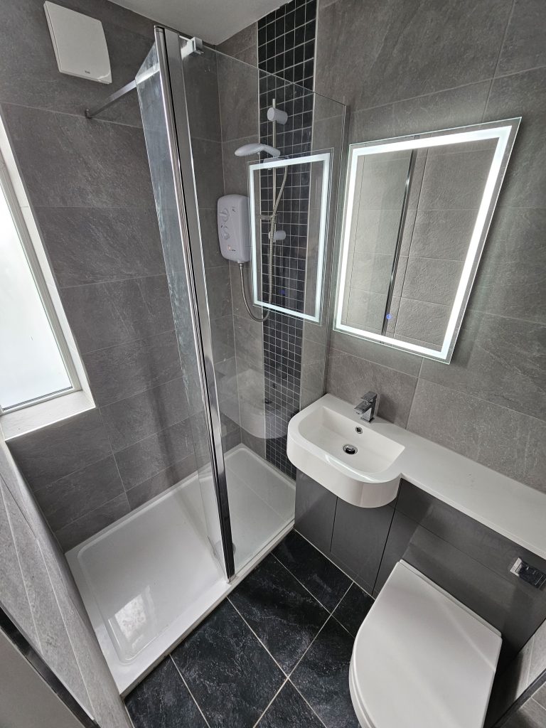 Grey tiled bathroom with electric shower, supplied and fitted by Premier Gas Burnley