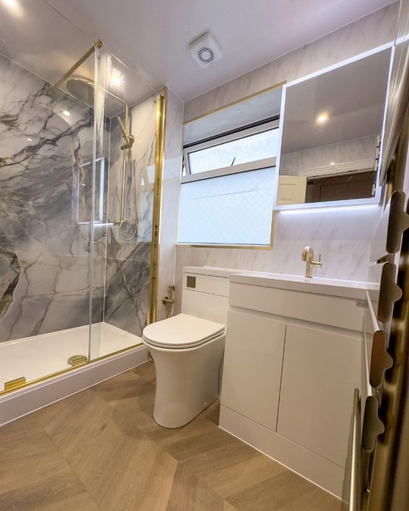 Marble walk-in shower with gold taps, a bathroom fitted by Premier Gas Burnley