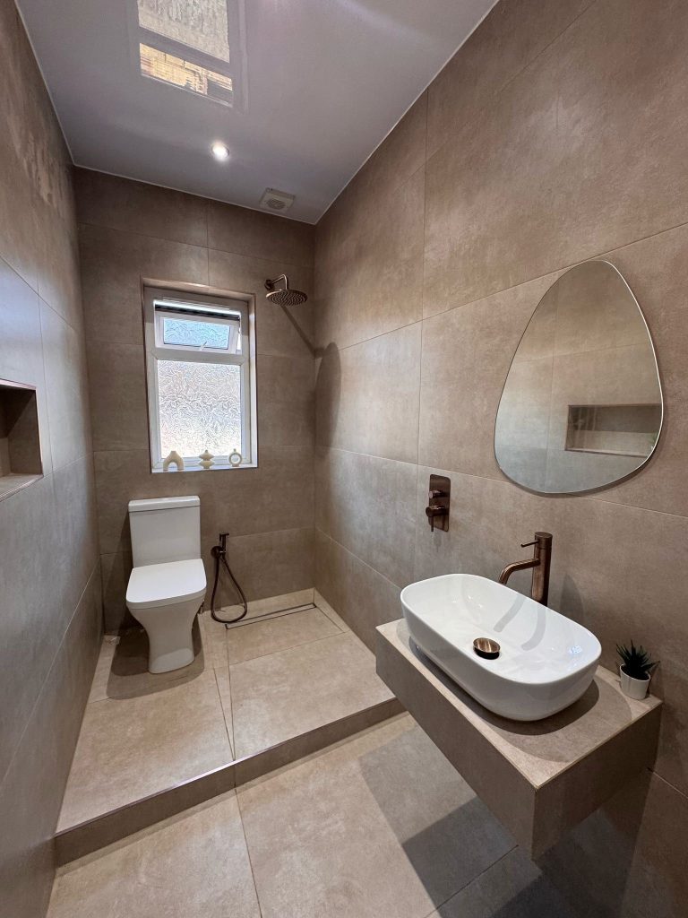 Taupe tiled wet room with copper taps, installed by Premier Gas Burnley