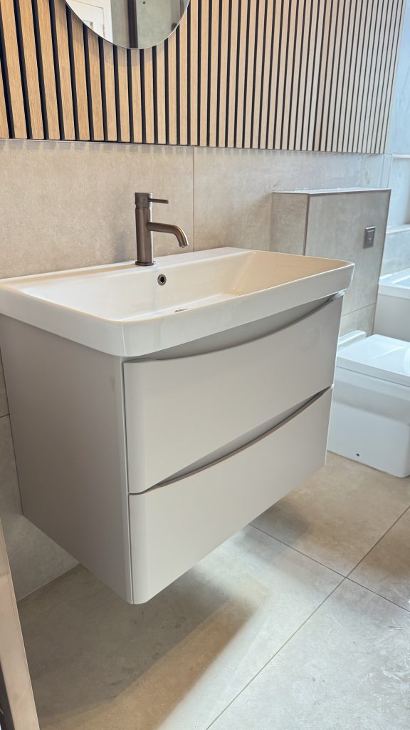 White curved vanity unit with oak slat wall panelling, installed by Premier Gas Burnley